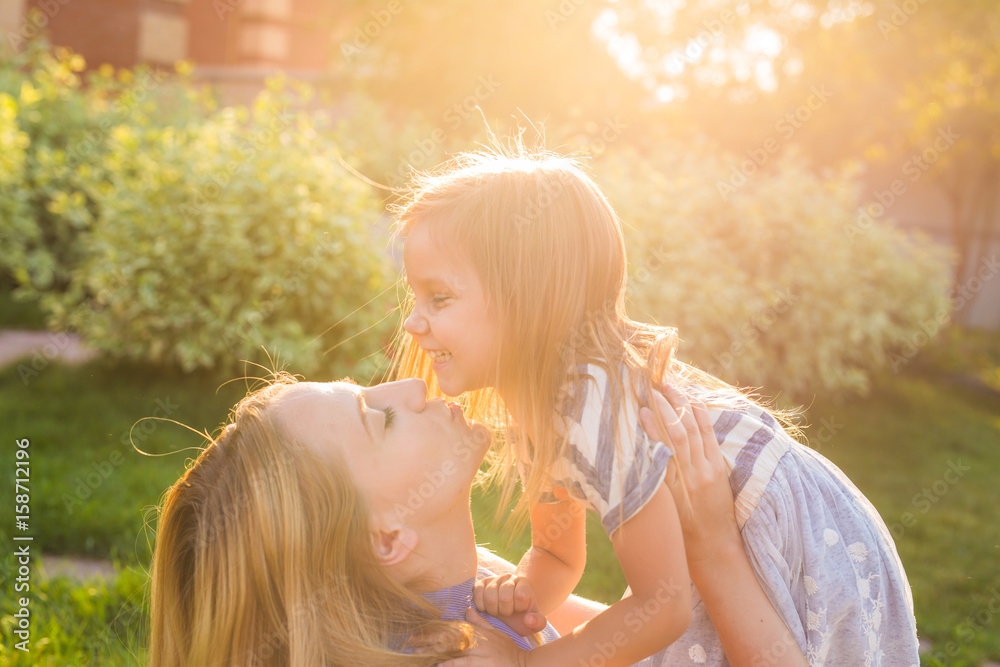 Wall mural portrait of happy loving mother and her baby outdoors.