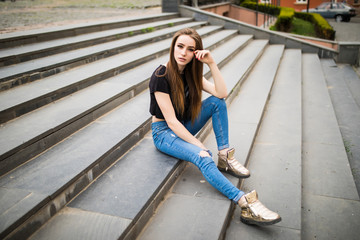 Beautiful young woman executive in the city sitting on stairs