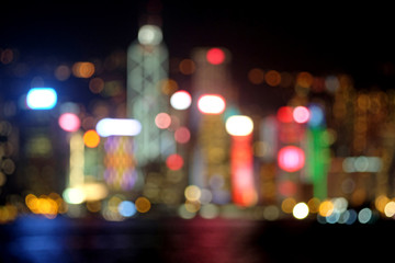 Colorful defocused or blurry night photo of a city beside a bay