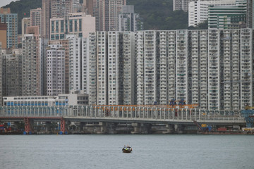 Obraz premium Moving boat in a river surrounded by high buildings
