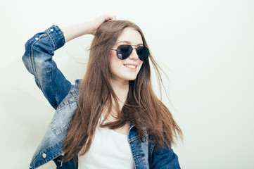 Attractive woman wearing aviator sunglasses happy smile on light background. Close up portrait