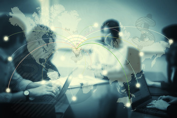 Blurred employees brainstorming in meeting room with world map with worldwide connection. Business background concept. Elements of this image furnished by NASA.