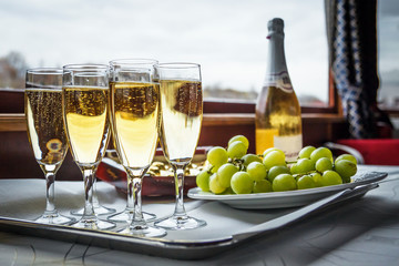Champagne in glasses, bottle and grapes on the table