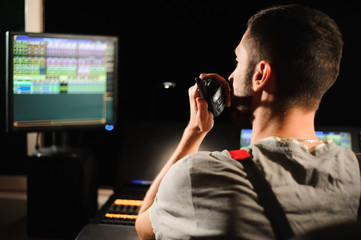 A lighting engineer works with lights technicians control on the concert show. Professional light...