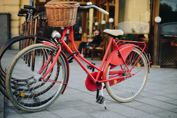 Fototapeta na wymiar old retro bike with basket in stand on bike park in the city