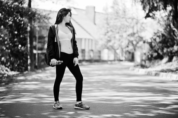 Fitness sport girl in sportswear and backpack with bottle of water in the street, outdoor sports, urban style.