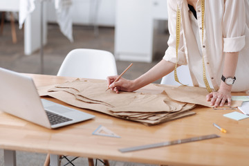 Female hands writing on a dress-pattern