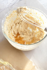 MIxing baking ingredients in a bowl for cake or pancakes. Light food photography concept