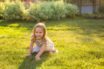 Naklejka na ściany i meble Cute little girl on the meadow in spring or summer day