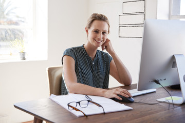 Obraz premium Smiling white woman working in an office looking to camera