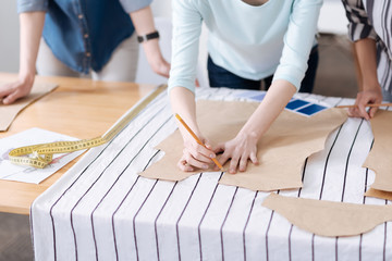 Delicate female hands tracing patterns on fabric