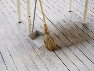 Broom and dustpan on old wood floor