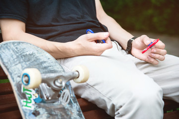 The man is sitting and twisting his fingers in his hand