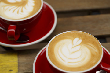 Coffee in red cup on wooden table, Colorful photo of coffee with defocused table in the background, Selective focus with shallow depth of field