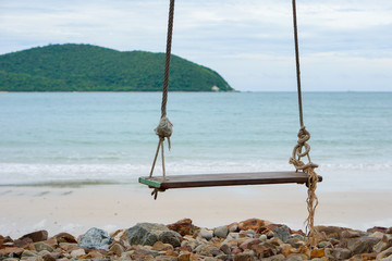 Swings on the sand tropical beach.