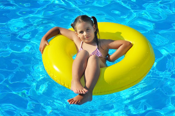 Adorable toddler relaxing in swimming pool