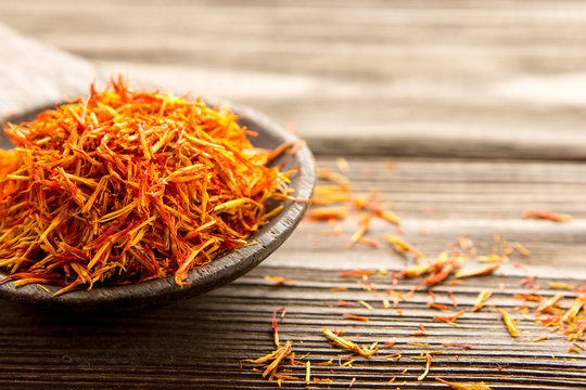 Spice saffron in a wooden spoon on the table.