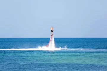 Fotobehang Man op een flyboard in de zee © guardalex