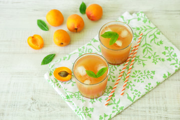 Apricot juice with ice cubes and apricots.