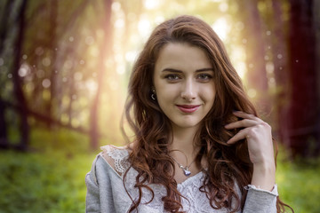 Obraz premium Girl with long hair in the park against the setting sun