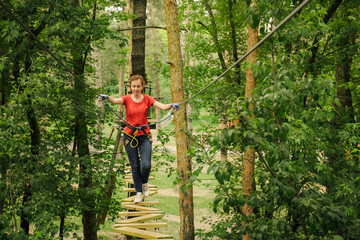 Woman climbing in forest adventure rope park