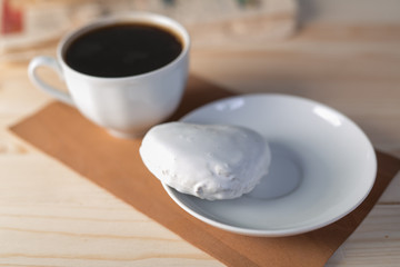 white coffee cup and gingerbread on wooden desk