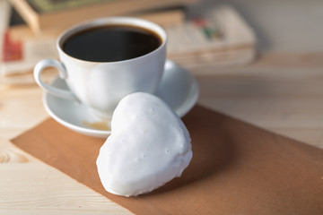 white coffee cup and gingerbread on wooden desk