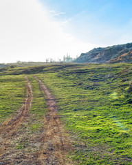 Fototapeta na wymiar Beautiful landscape - the dirt road running across the field
