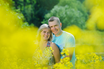 Happy couple in yellow rape field.