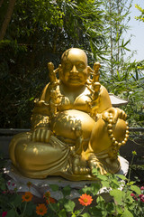 Jolly chubby Buddha statue in front of small Buddhist temple on Marble Mountains near Da Nang Vietnam