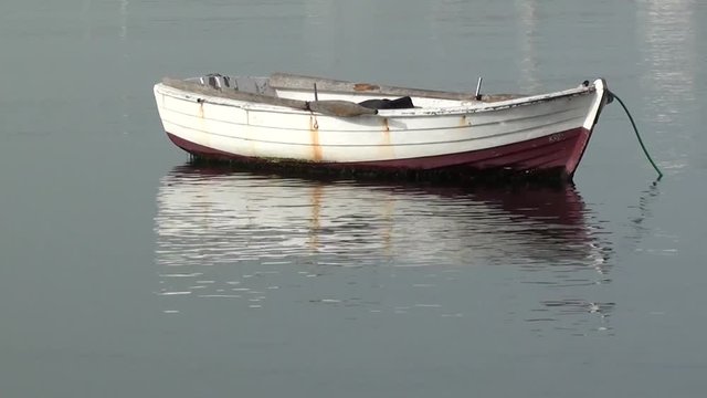 Old small white boat on water 