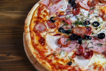 Delicious homemade pizza with mozzarella, ham, olives and fennel.