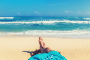 Man enjoying at the beach - focus is on feet.