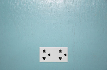 Double plug socket on the wall on wood  background