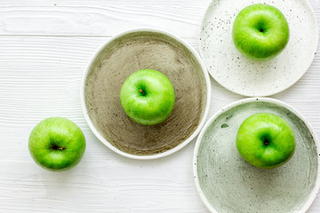 Healthy green food with apples on plates white background top view