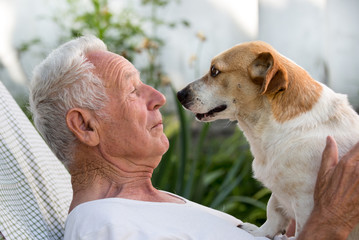 Old man and cute dog kissing