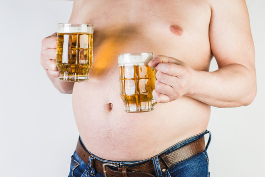 A man with a big belly holding a glass of beer in his hand.