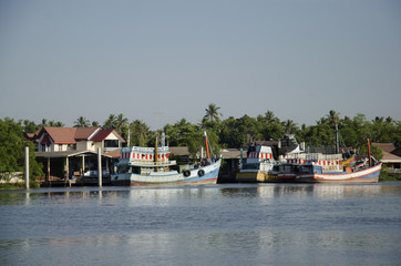 Fototapeta na wymiar Wooden fishery boat floating and stop wait for go to catching fish in the sea in evening time at Mae klong river