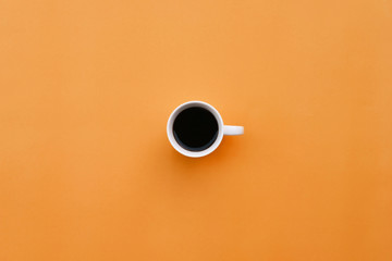Cup of coffee on orange background