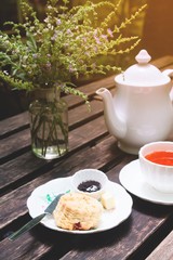 Set of tea break with scone and strawberry jam on wooden table