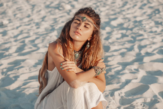 attractive bohemian style woman lying on the sand
