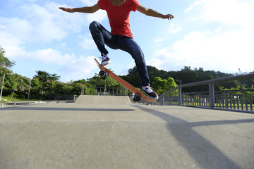 young skateboarder legs skateboarding at skatepark