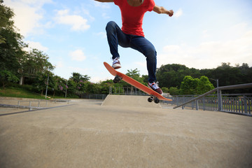 young skateboarder legs skateboarding at skatepark