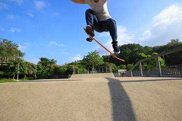 young skateboarder legs skateboarding at skatepark