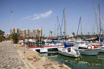 Boat and yacht on a bright sunny day in the seaport of Marina de las Dunas, Guardamar del Segura, Alicante, Spain.