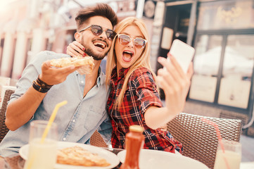 Schönes junges Paar, das im Café sitzt und Pizza isst. Konsum, Essen, Lifestyle-Konzept
