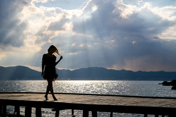 Fototapeta premium Girl at sunset on the pier