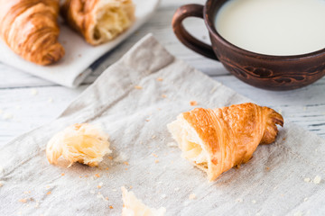 Breakfast with croissants and milk. White rustic table