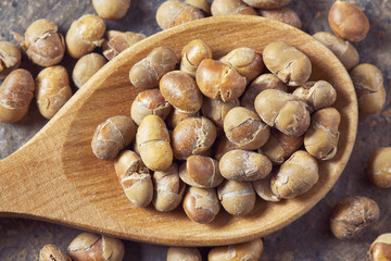 Roasted soybeans (soy nuts) in wooden spoon. Top view