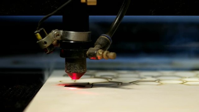 Side view laser cutting machine at work on wood